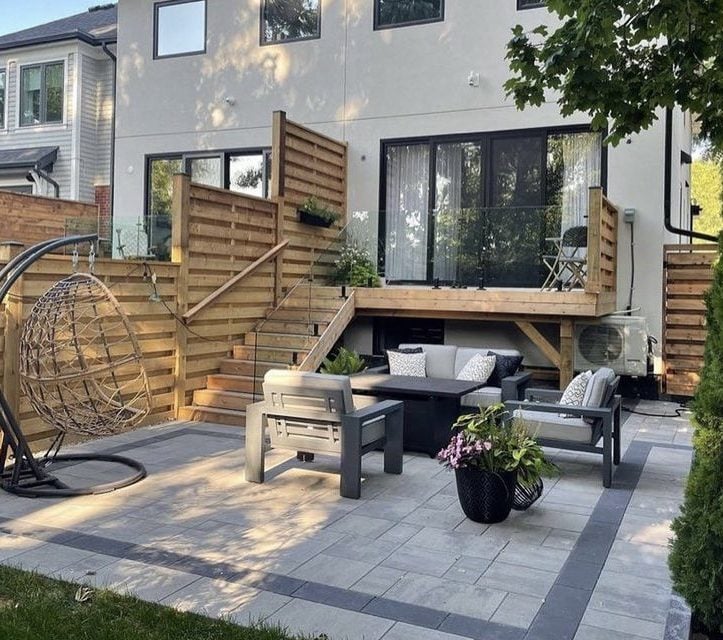 Finished backyard patio with elevated cedar deck and horizontal slat privacy fence, pool landscaping Guelph by BCI Landscaping