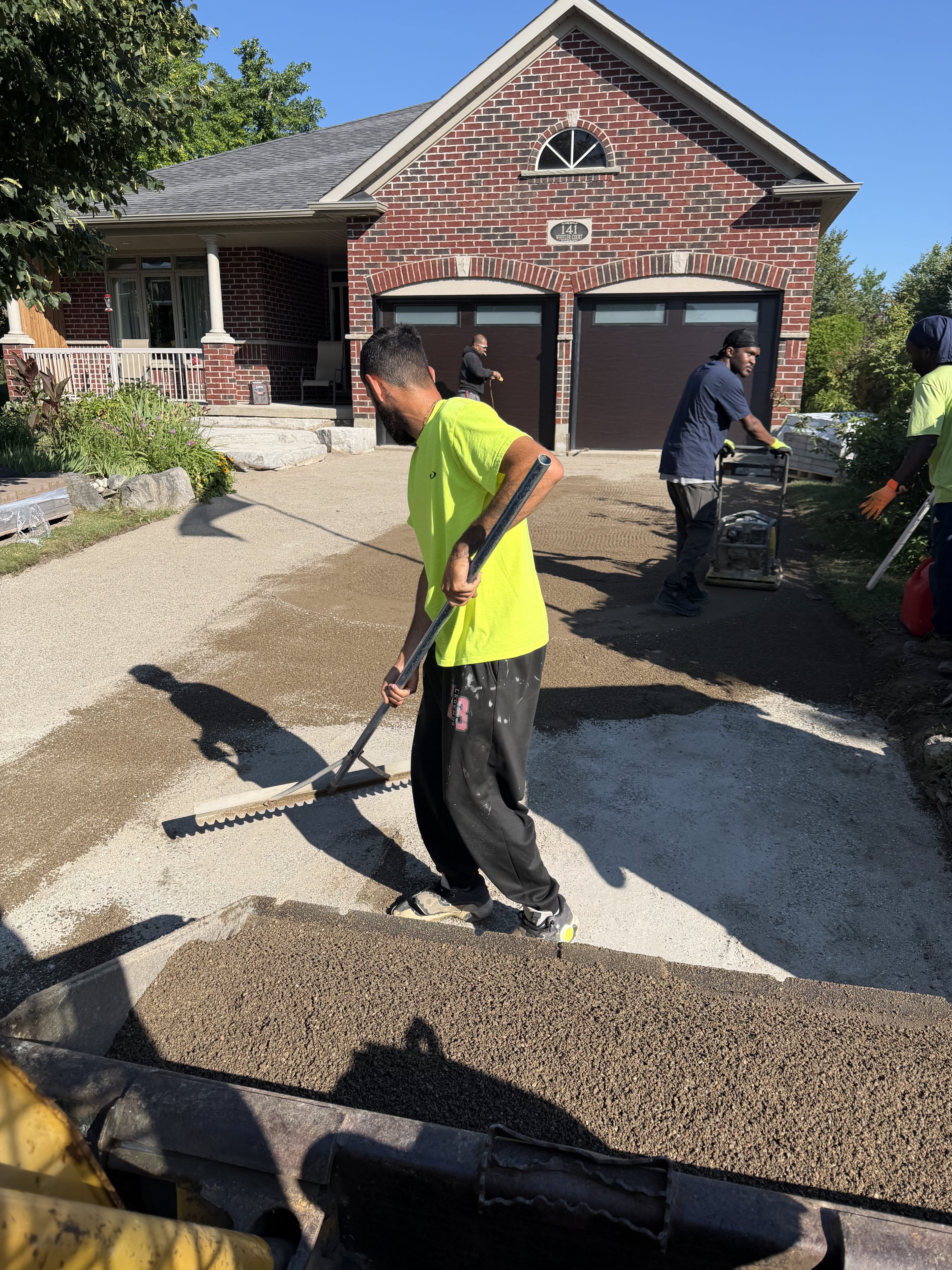 BCI Landscaping crew preparing granular base during site prep, pool landscaping Guelph