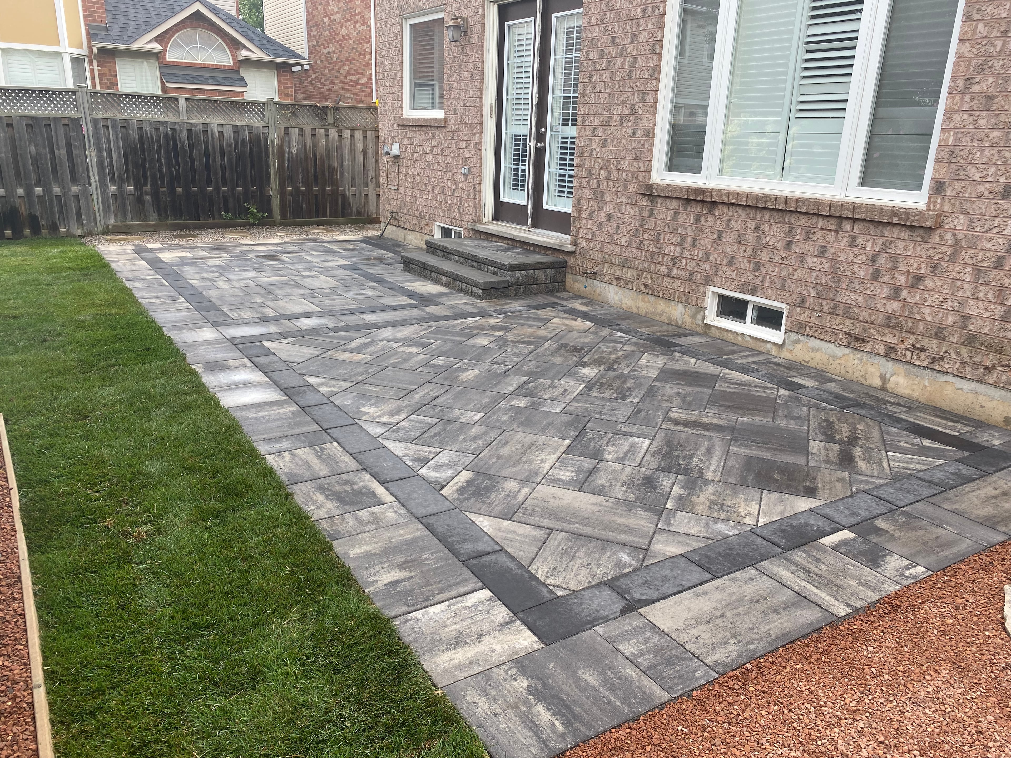 Guelph backyard interlocking patio with herringbone pattern and charcoal border accent installed by BCI Landscaping