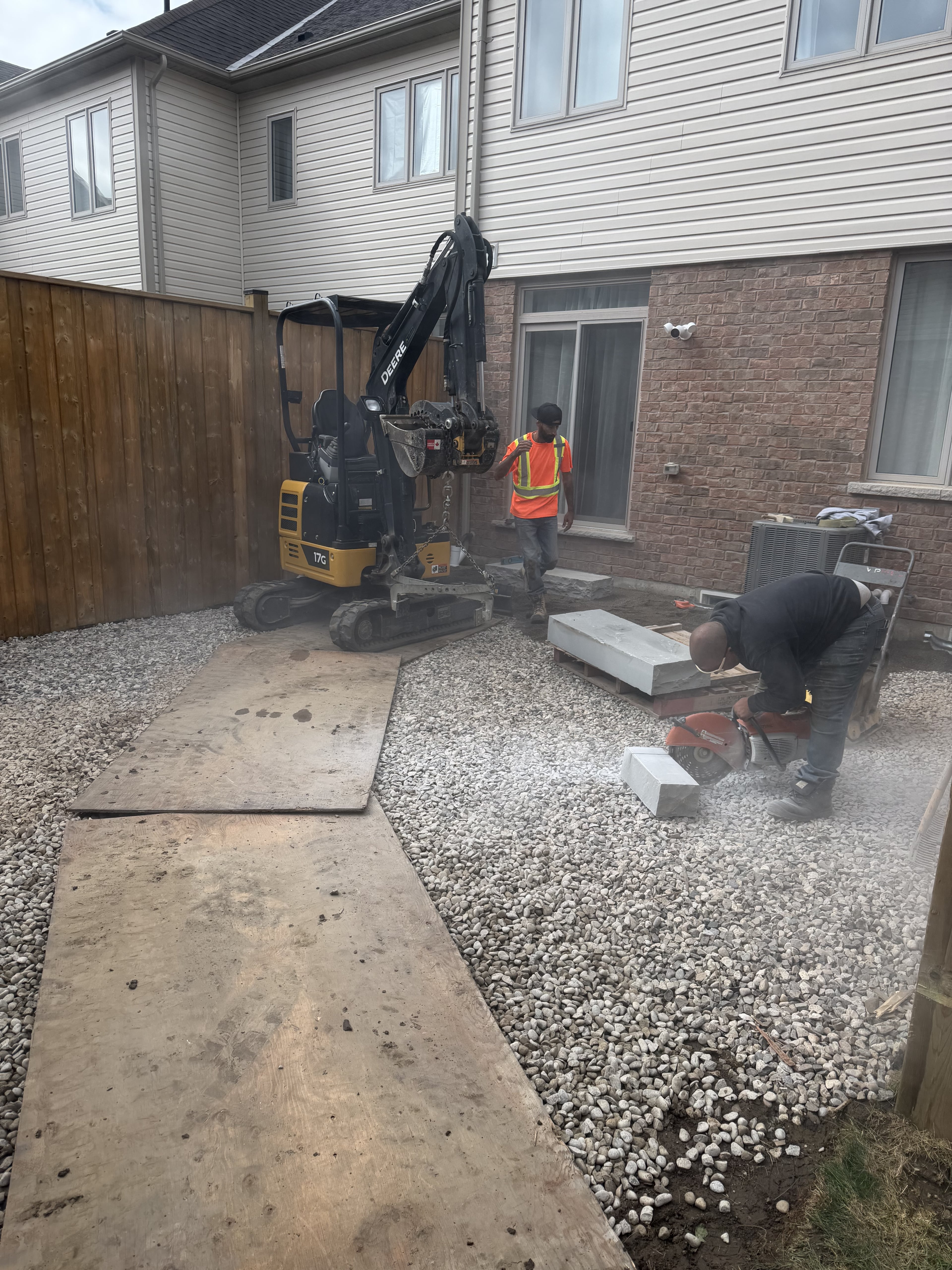 BCI Landscaping crew operating mini-excavator during base preparation on a Guelph landscaping project