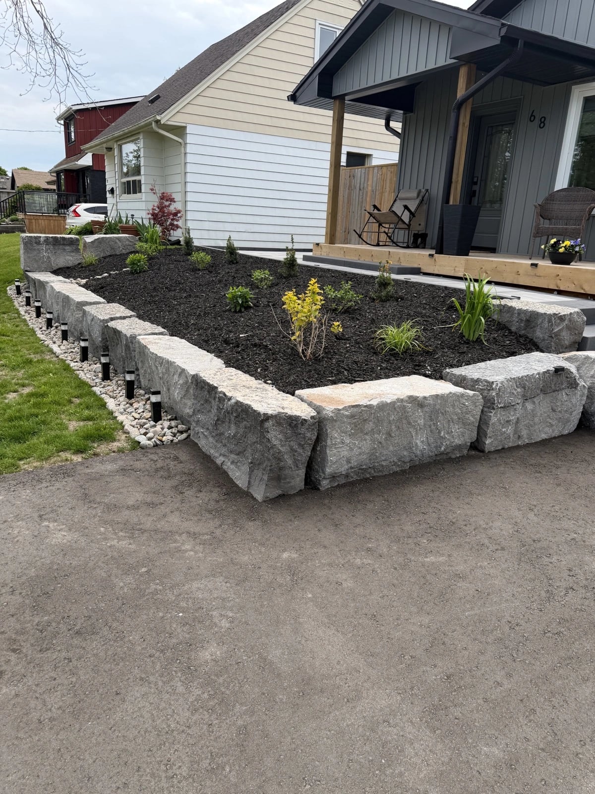 Armour stone garden border with fresh mulch and new plantings in a Guelph front yard