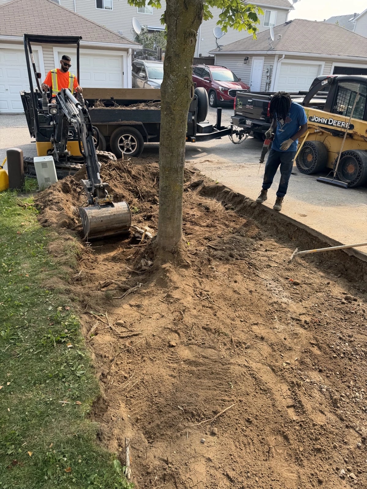 Drainage trench excavation in a front yard with mini-excavator and crew, drainage solutions Guelph by BCI Landscaping