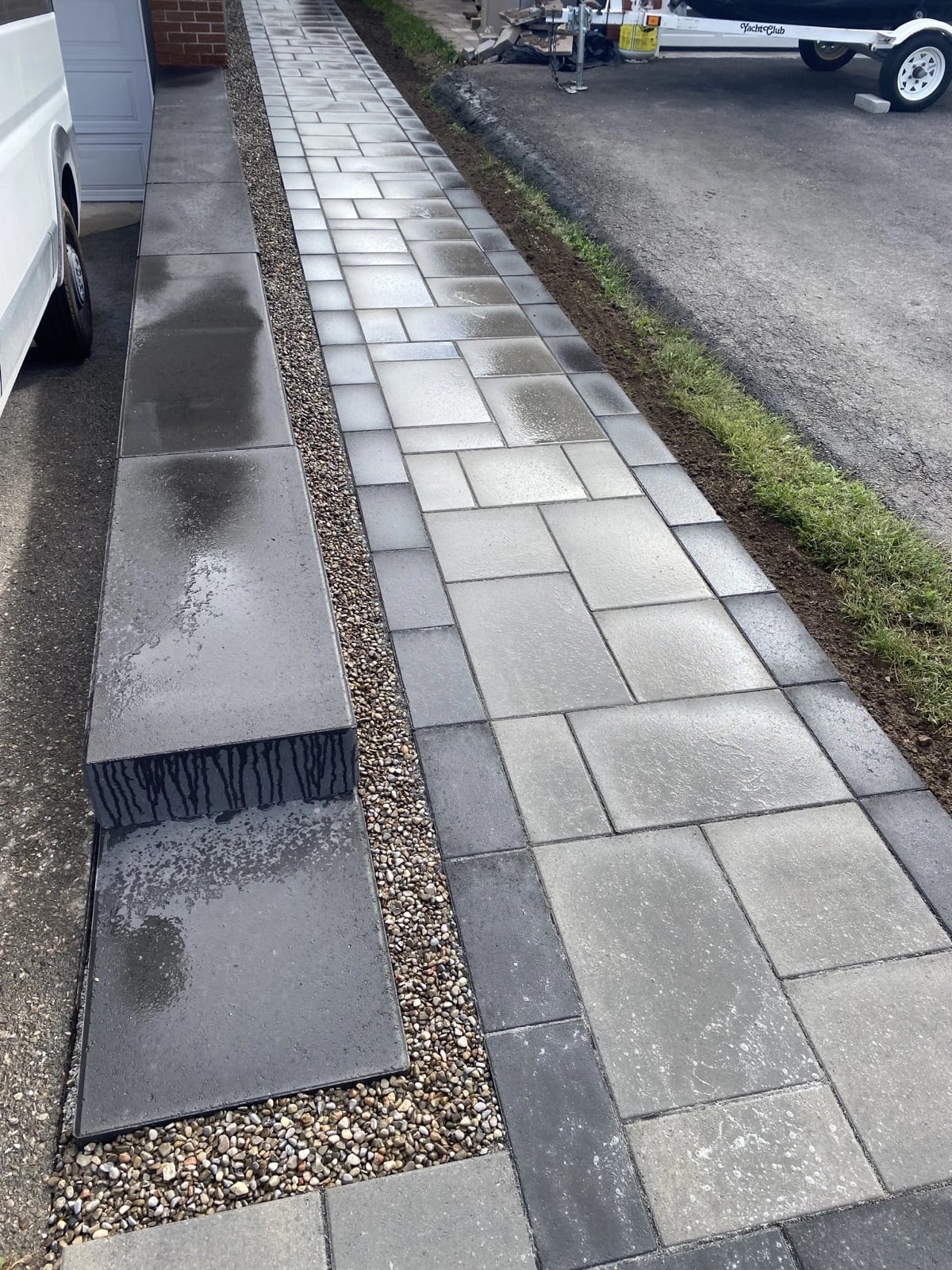 Large-format interlock walkway with charcoal accent pavers along the side of a home, interlocking walkways Guelph